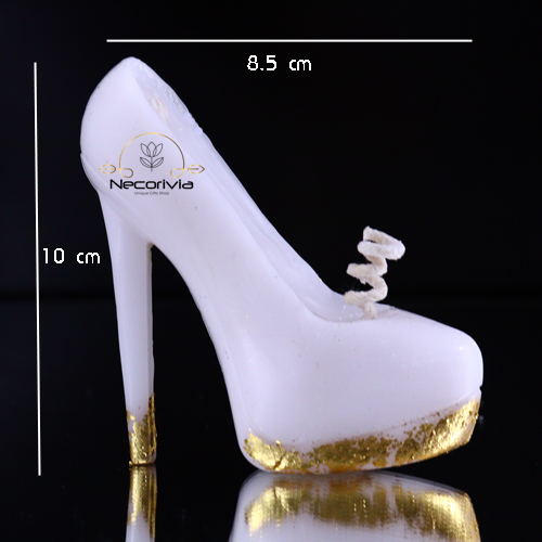 White high-heel shoe candle with gold accents and decorative spiral detail.